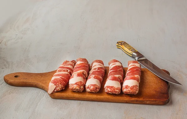 Rolle mięsne i nóż — Zdjęcie stockowe