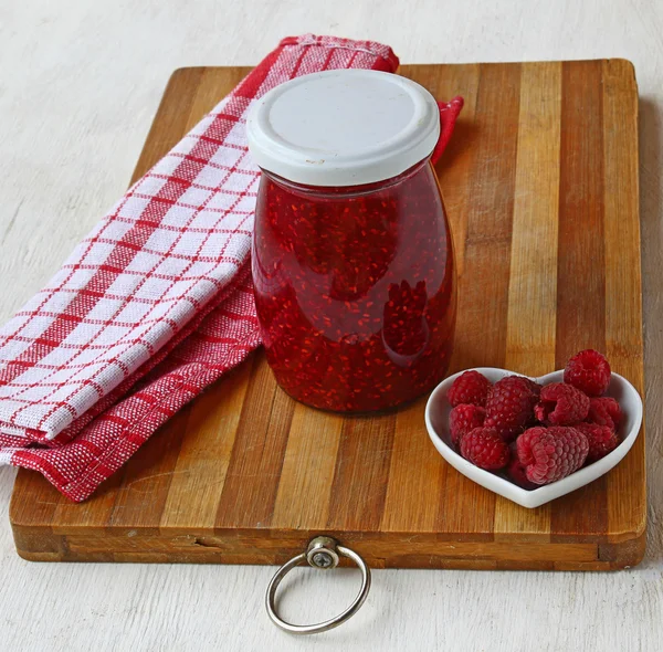 Raspberry on a background of jars of jam — Stock Photo, Image