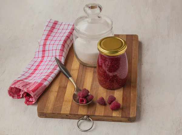 Frambozen op een achtergrond van potten jam en suiker — Stockfoto