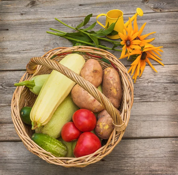 Korb mit Gemüse und ein Bouquet von gelben rudbeckia — Stockfoto