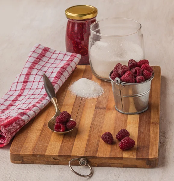 Raspberry on a background of jars of jam and sugar — Stok Foto