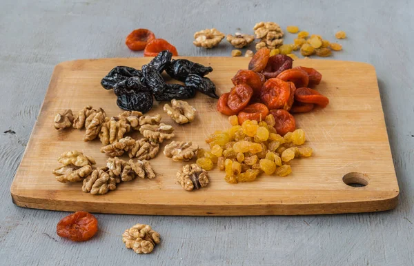 Walnoten Pruimen Rozijnen Gedroogde Abrikozen Een Snijplank Keukentafel — Stockfoto