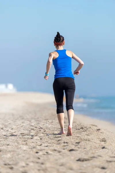 若い女性が朝砂浜を走り — ストック写真