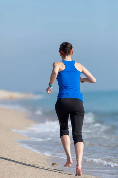 若い女性が朝砂浜を走り — ストック写真