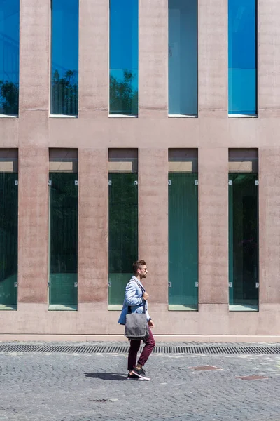 Businessman Walking Next Office Buildings While Holding Shoulder Bag — Stok fotoğraf