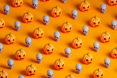 Turuncu arka planda birçok Cadılar Bayramı kabağı ve beyaz kafatasının 3 boyutlu eşölçümleme deseni
