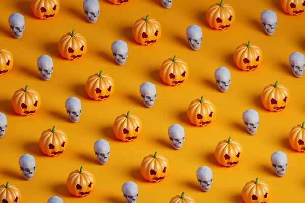 Turuncu arka planda birçok Cadılar Bayramı kabağı ve beyaz kafatasının 3 boyutlu eşölçümleme deseni