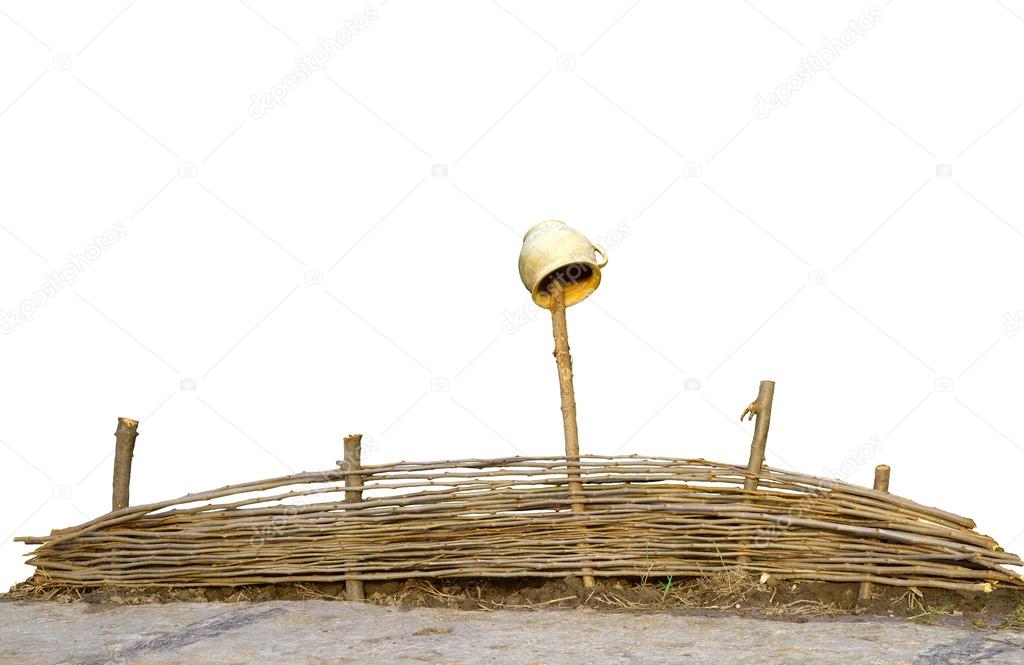 Wicker fence with an old pot isolated on white