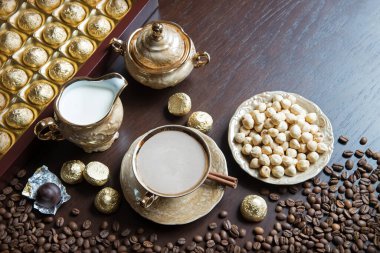 Folyo, kakao, kafein, bonbon partisi, ahşap masa yazı alanı. Yakın çekim eski antika taze koyu kahve tohumu kokulu mutfak tezgahı kakao taneli çömlek sürahisi pişiriyor.