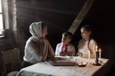 Yaşlı Yahudi mülteci kadın anne, lütfen dikkat et. Endişe et. Ekmek, umut ver. Karanlık retro Yahudi ev odası masası. Büyük savaş sıkıntısı, teneffüs yemeği kıtlığı endişesi.