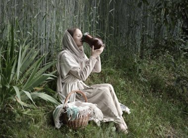 Yetişkin İsrailli Yahudi fakir İncilli halk işçisi cüppeli elbise giysi kolu saf kilden şişe tenceresi. Mutlu İncil. İbrani gençler süt çiftliği işçisi, çocuk çocuk, orman parkında çimen yetiştiriyor.