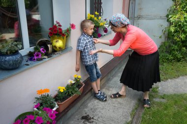 Öfkeli anne uyardı. Öfkeyi azarla. Argu 'nun kirli hatası. Futbol tekmeleme oyunu küçük üzgün düşme oyuncağı suçlu bölünmüş enkaz kırılma çatlak kayıp toprak toprak saksı vazosu