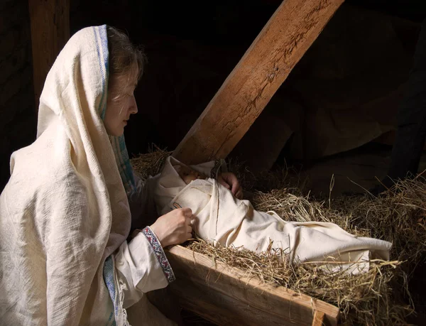 Happy young boy cradle sleep life symbol star light white cloth greet card text space. Dark black stable barn cave hay straw live scene cute new parent merry Lord messiah noel eve love joy lady hand