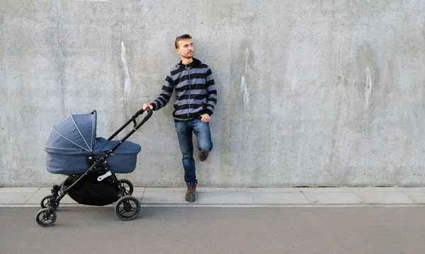 Schöner Vater Mit Neugeborenem Kinderwagen Der Neben Grauer Betonwand Steht — Stockfoto