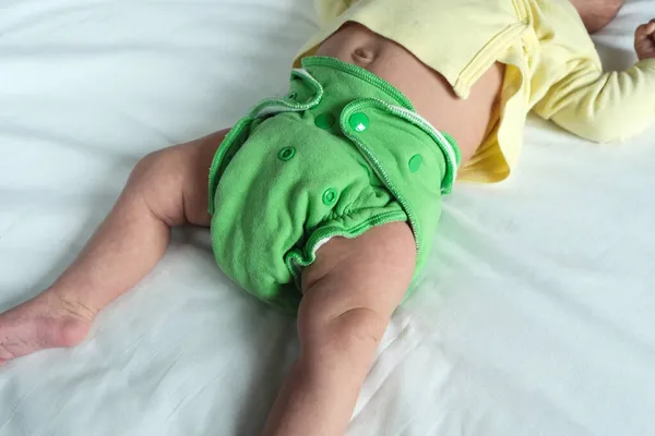 Neugeborenes Baby Grüner Mehrwegwindel Auf Weißem Laken Moderne Umweltfreundliche Stoffwindel lizenzfreie Stockbilder