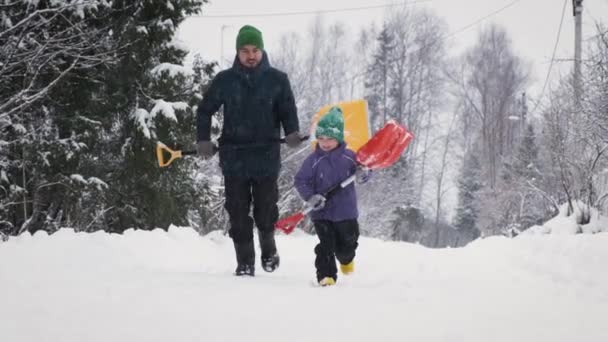 Padre Hijo Divierten Invierno Corriendo Con Palas Nieve Cámara Camino — Vídeo de stock