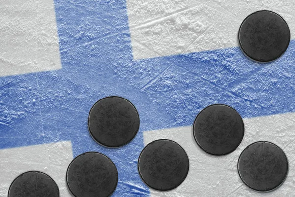 Bandera finlandesa y arandelas en el hielo — Foto de Stock