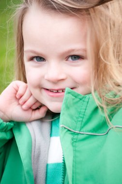 Yeşil ceketli gülümseyen küçük kız