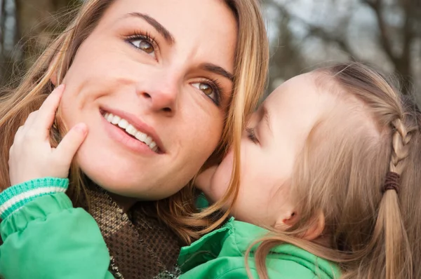 Vrouw listnening haar dochter met glimlach — Stockfoto