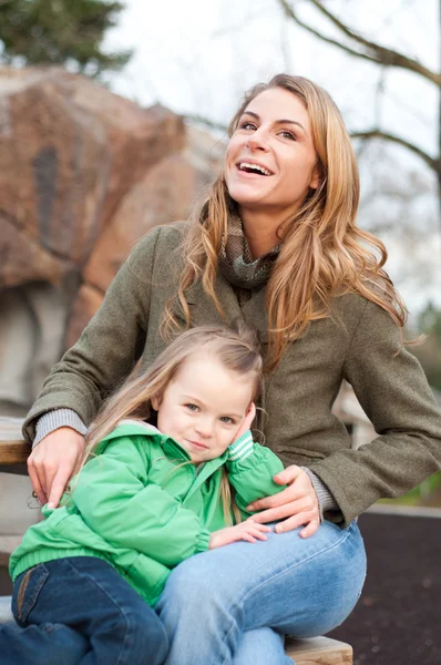 Smiling young woman with daughter — Stock Photo, Image