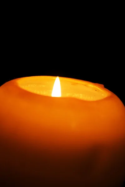Yellow candle on black background — Stock Photo, Image