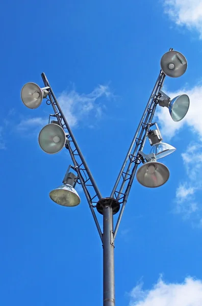 Modern pole with spotlights and blue sky with clouds behind — Stock Photo, Image