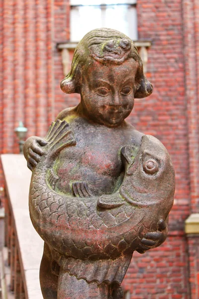 Staty av pojke med fisk nära Stadshuset i stockholm, Sverige — Stockfoto