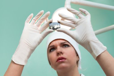 Doktor Diş röntgeni ele alıyor.