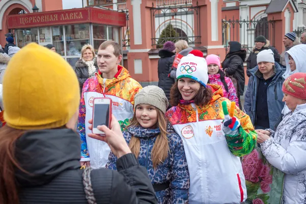 11 gennaio 2014, Saratov, Russia. Relè Torcia Olimpica Sochi 2014. Spettatori fotografati con un membro del relè — Foto Stock