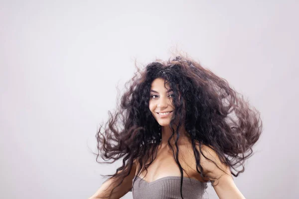 Havada Uzun Kıvırcık Saçlı Güzel Esmer Kız Stüdyo Portresi Mutlu — Stok fotoğraf