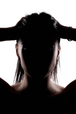 Saçlarını elleriyle tutan esmer bir kızın silüet portresi..