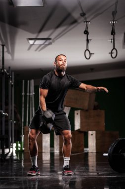 Kas sporcusu çok ağır ağırlık kaldırıyor. Adam içeride çalışıyor.