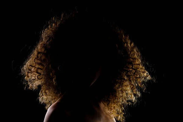 侧光发亮的黑发女孩长卷发 黑暗背景的轮廓工作室肖像 — 图库照片