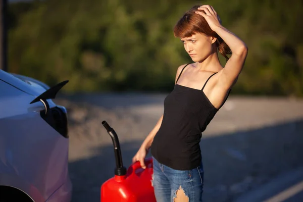 Μπερδεμένο Κορίτσι Προσπαθεί Βάλει Βενζίνη Από Ένα Κόκκινο Κάνιστρο Ένα — Φωτογραφία Αρχείου