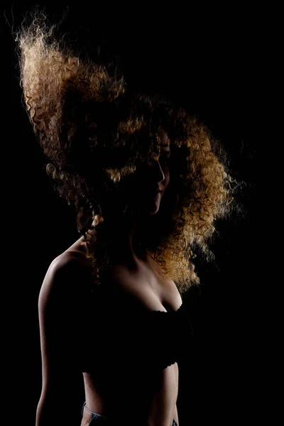 Podświetlana Brunetka Długimi Kręconymi Włosami Powietrzu Sylwetka Studio Portret Ciemnym — Zdjęcie stockowe