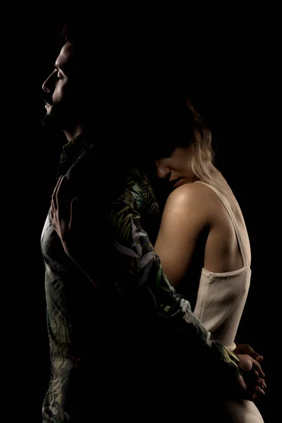 黒を背景にポーズをとるカップル 女の子抱擁男の子で影の後ろから — ストック写真