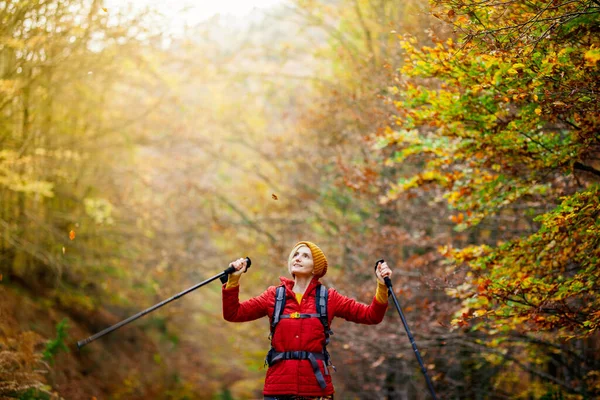 带着杆子和背包在小径上远足的女孩 手举起来享受大自然 秋天外出旅游及健康生活 — 图库照片