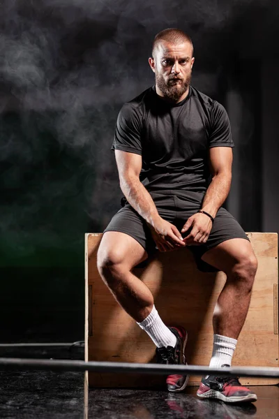 Мускулистый Спортсмен Позирует Тяжелой Атлетикой Фон Дыма — стоковое фото