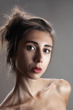Güzel esmer kız stüdyo resmi. Ciddi yüz ifadesi.