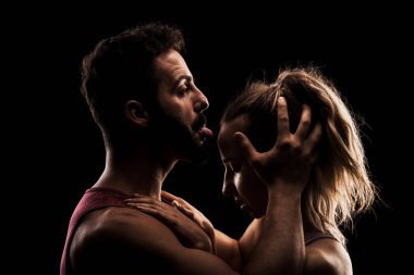 Uygun çift birlikte poz veriyor. Erkek ve kız tarafı siyah arka planda aydınlık siluetler..