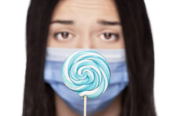 Ağzı Tıbbi Maskeyle Kaplı Üzgün Bir Kız Lolipop Tutuyor — Stok fotoğraf