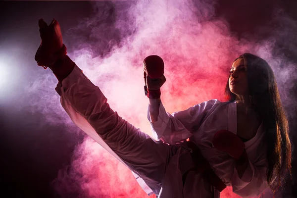 Flicka Utövar Karate Ben Spark Mot Röd Dimma Bakgrund — Stockfoto