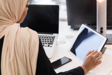 Ofiste tablet üzerinde çalışan tesettürlü Afrikalı Müslüman kız..
