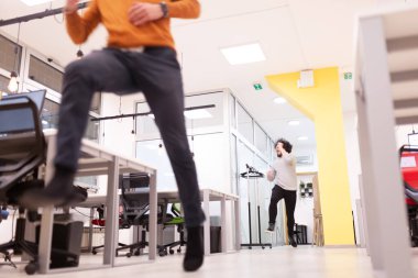 Ofiste eğlenen iki iş adamı. Dost canlısı meslektaşlar atlayıp dans ederek başarıyı kutluyor.