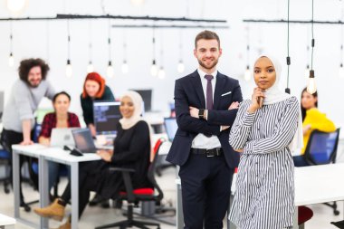 Modern bir ofis alanında iki çok ırklı meslektaş. Arka planda çalışan bir grup insan çeşitlilik ve başarı kavramı.