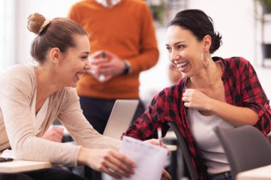 Öğrenciler sınıfta bir öğretim görevlisini dinliyor. Zeki genç kızlar gülüyor ve birbirlerine öğütler veriyorlar..