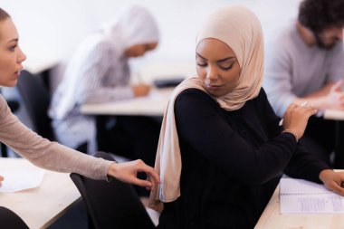 Sınıfta sınava giren öğrenciler. Akıllı genç kızlar konuşuyor ve birbirlerine tavsiye veriyorlar..