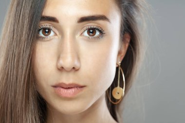 Güzel esmer kız stüdyo resmi. Ciddi yüz ifadesi.