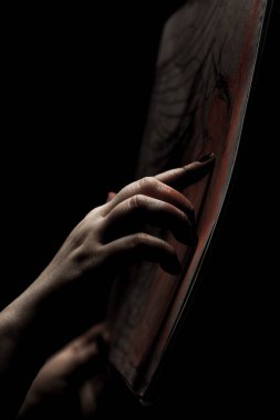 Sanatçı parmaklarıyla çiziyor. Siyah arkaplana karşı kağıt üzerinde soyut el resmi.