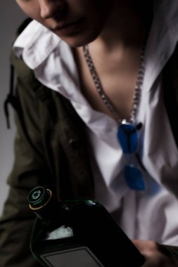 Elinde alkol şişesi olan güzel bir kızın stüdyo portresi..